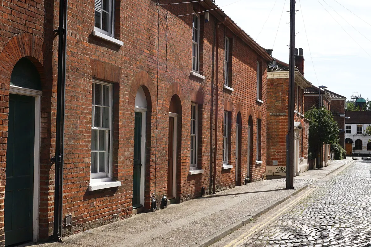 Brick homes lining a cobbled Norwich street
