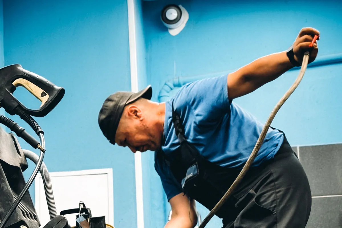 Plumber working over a pump in a workshop