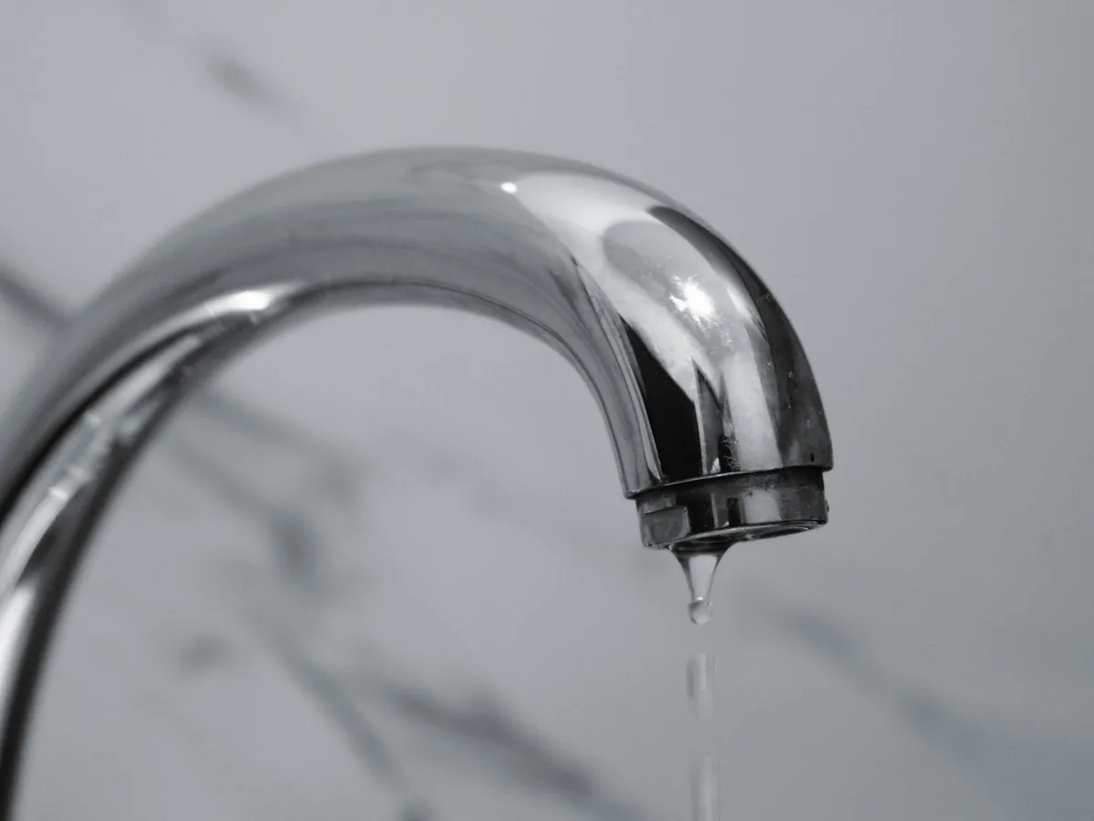Chrome tap dripping onto a marble surface