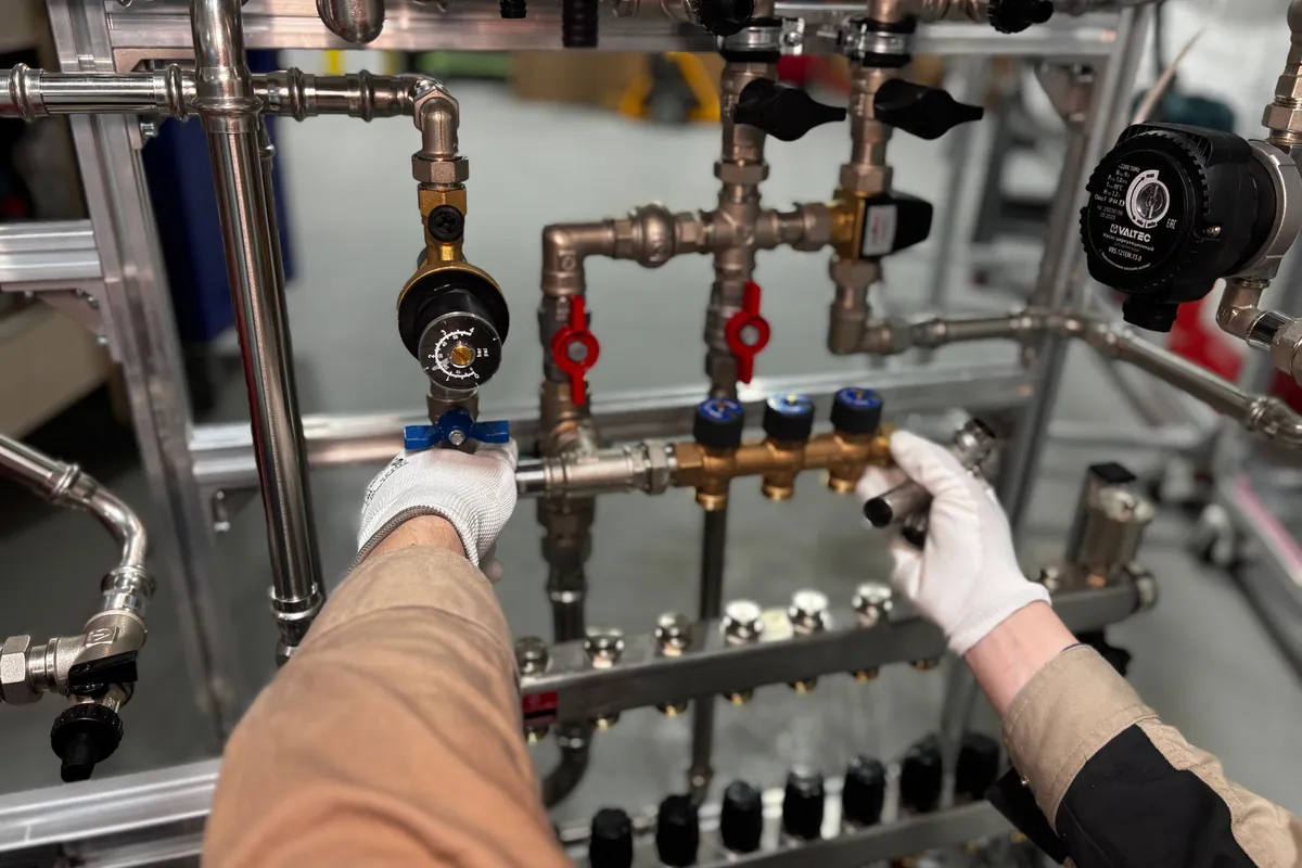 Engineer opening valves on a heating circuit