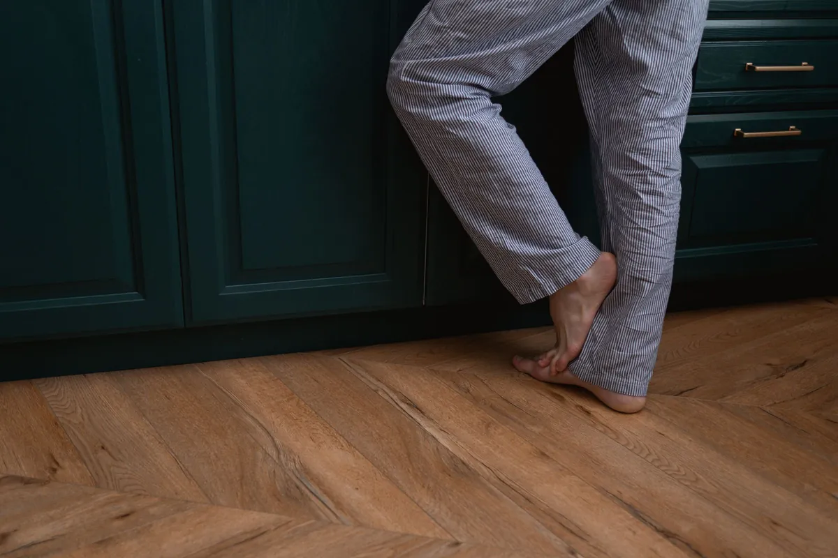 Bare feet on a warm wooden kitchen floor